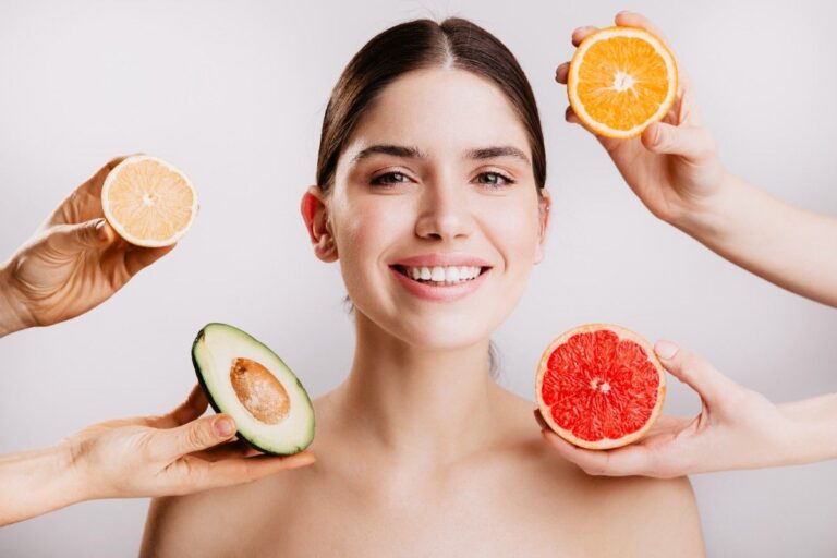 A bowl of fresh fruits, nuts, and leafy greens as part of a healthy diet for glowing skin