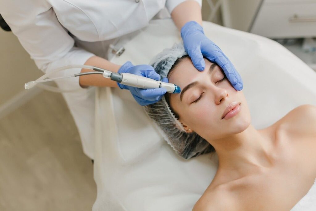 Skin Specialist Consultation in Palakkad with a dermatologist performing an advanced facial skin assessment using a professional dermatology device.